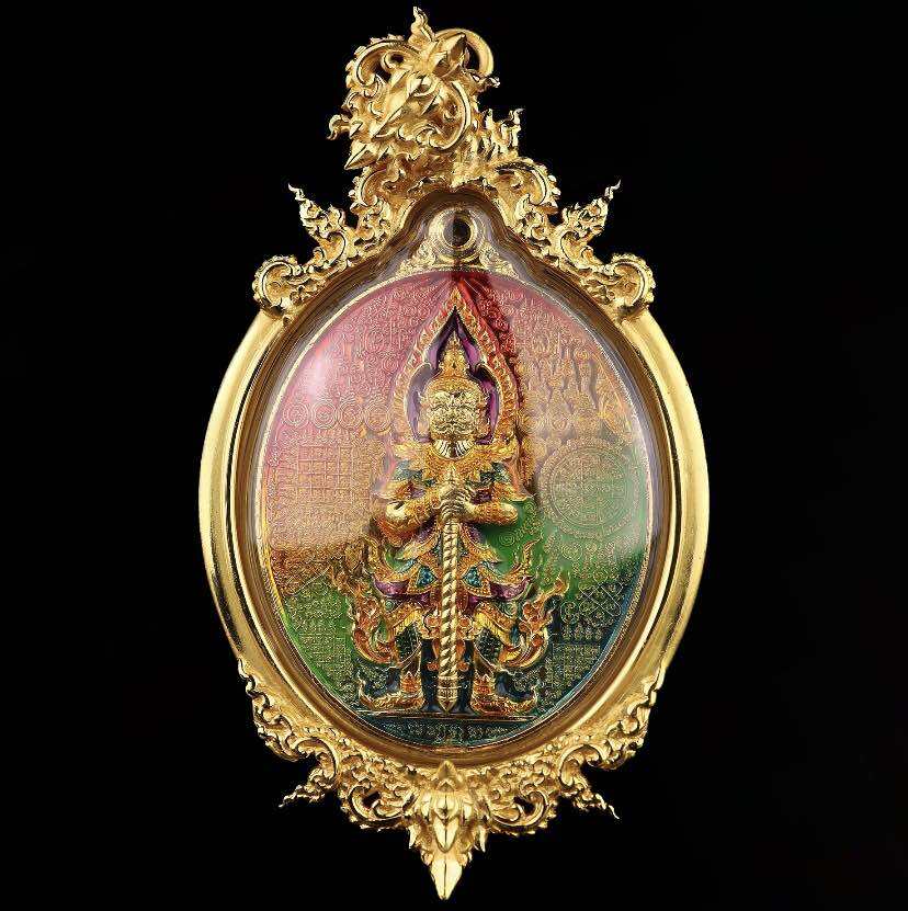 Gold ornate oval pendant with colorful guardian figure in filigree frame Thao Wessuwan wealth amulet