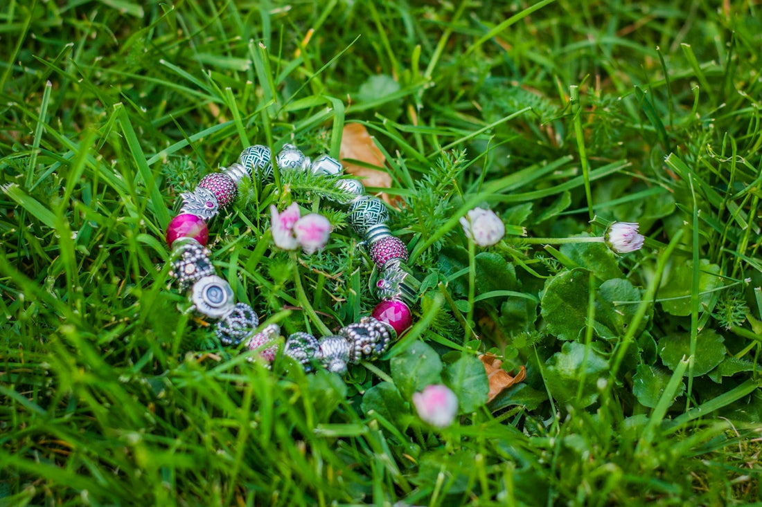 A bracelet lays gracefully in green grass
