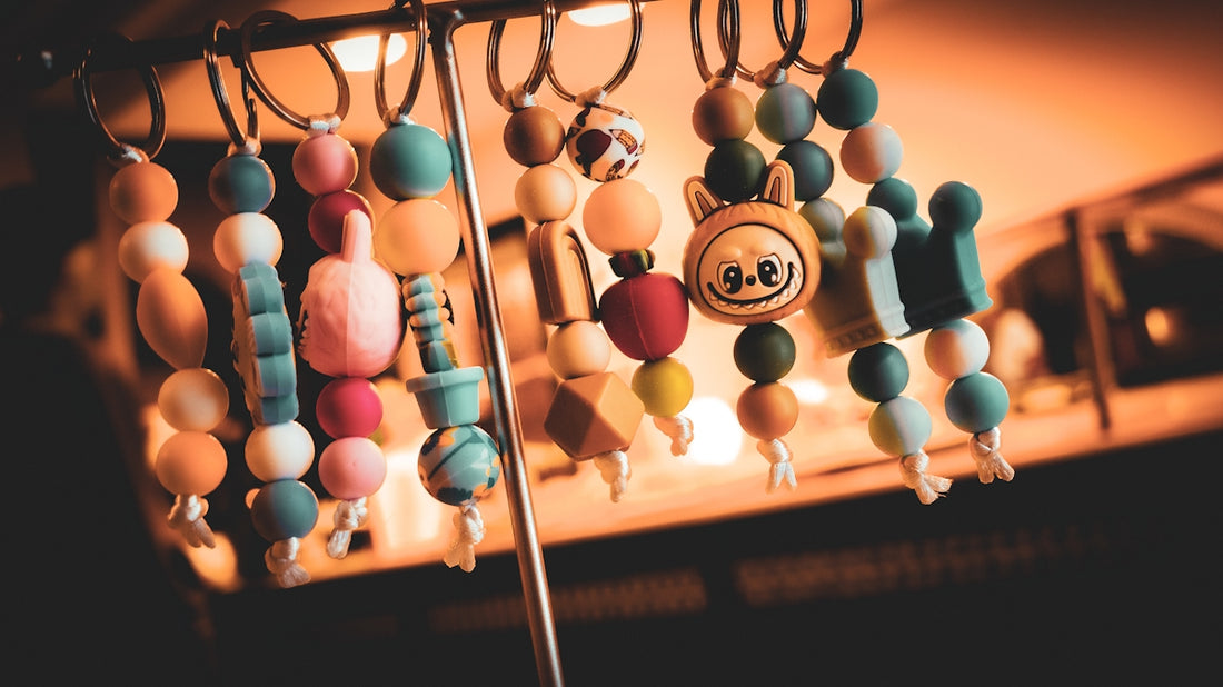 Colorful beaded keychains with various charms hanging.