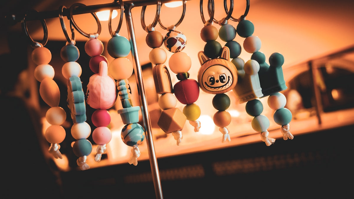 Colorful beaded keychains with various charms hanging.