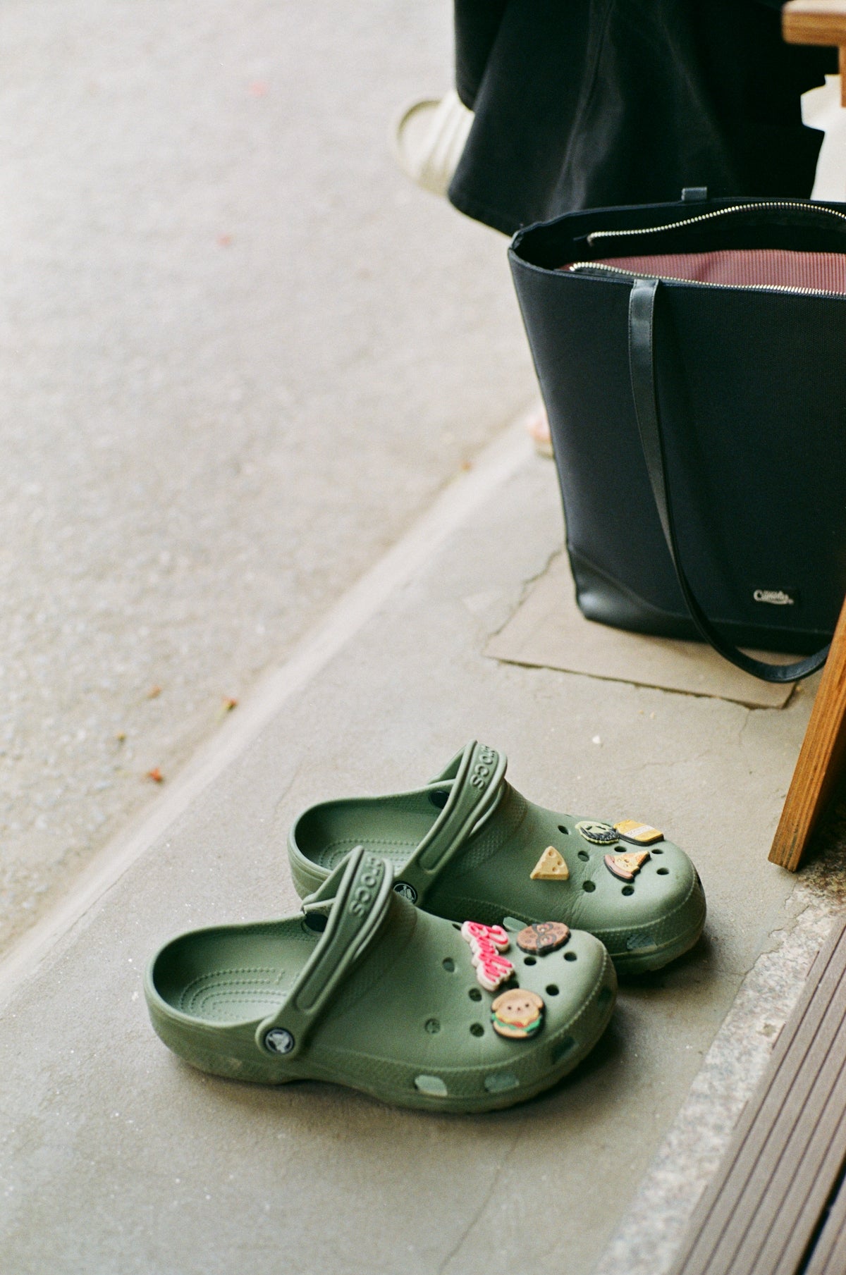 Olive green clogs decorated with fruit charms.