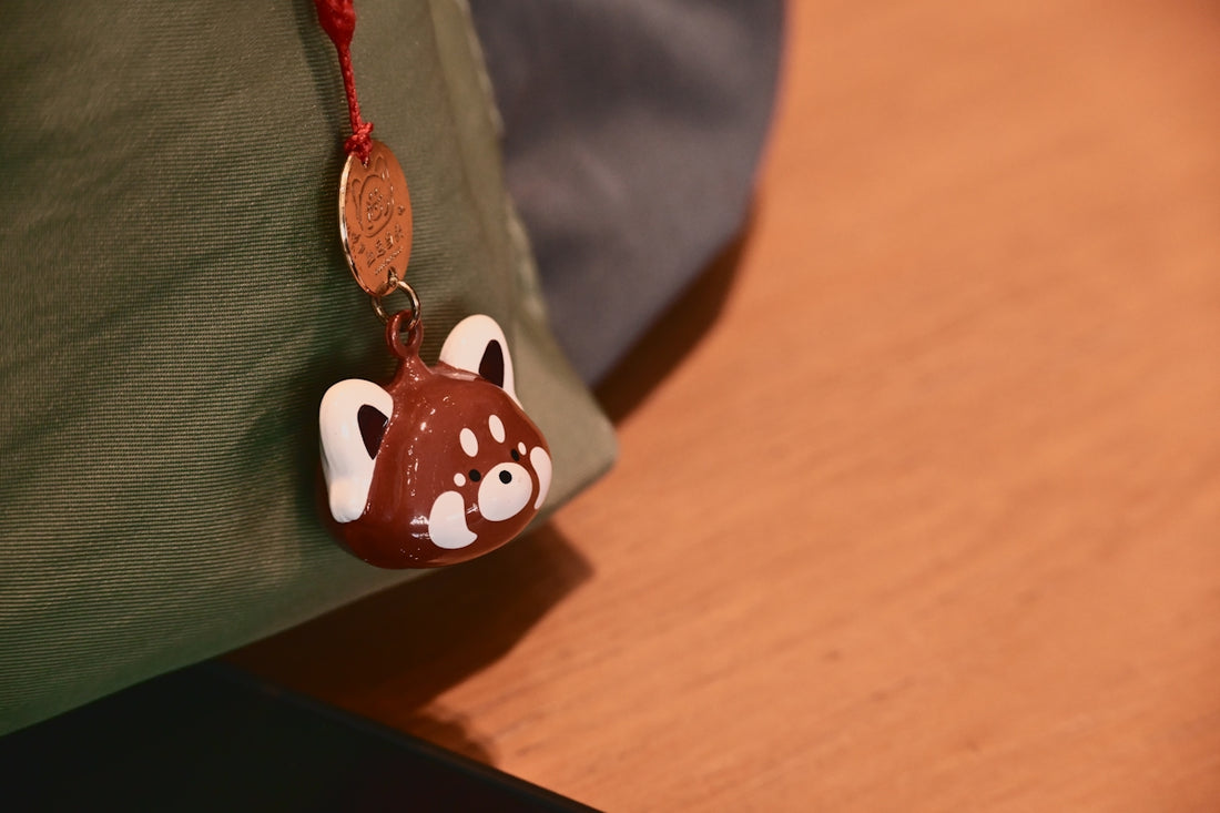 A red panda charm hanging from a bag.