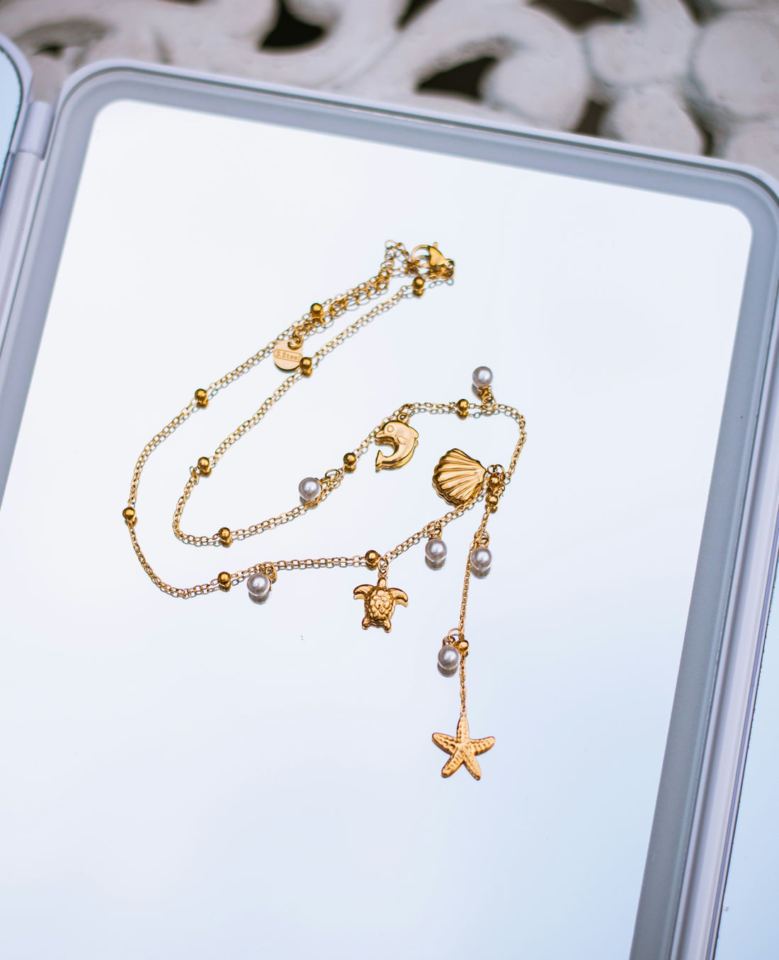 Gold chain anklet with sea life charms.