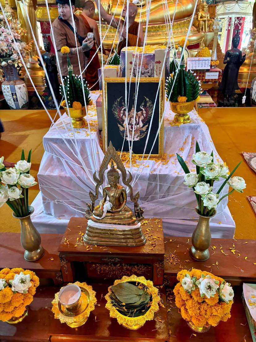 Ceremonial altar displaying an authentic Thai guardian amulet with flowers and offerings