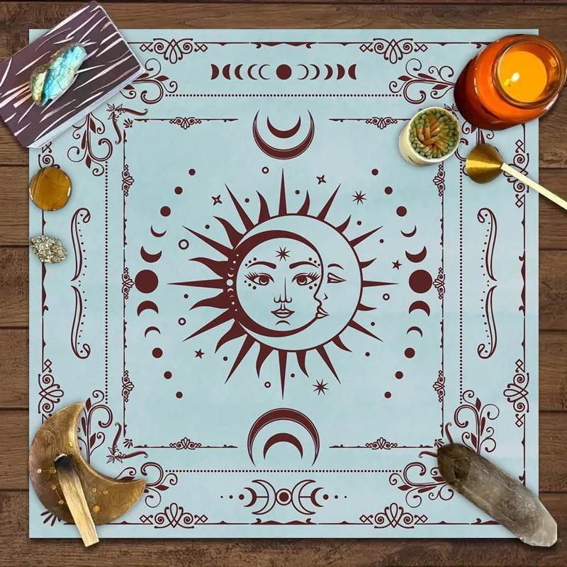Light blue astrology tarot tablecloth featuring a central sun and moon face with burgundy celestial motifs and crystals