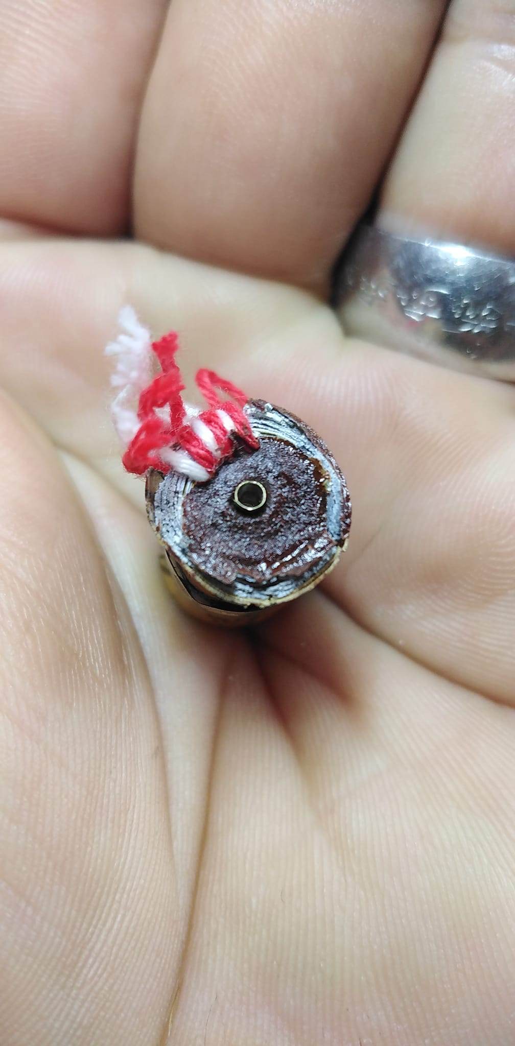 Thai fortune charm bracelet small amulet held in hand with red and white thread by Thai Blessing Co