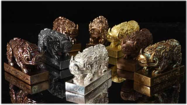 Phaya Moo Setthi Amulet - Luang Por Whan’s metal pig amulets in various finishes on reflective black surface