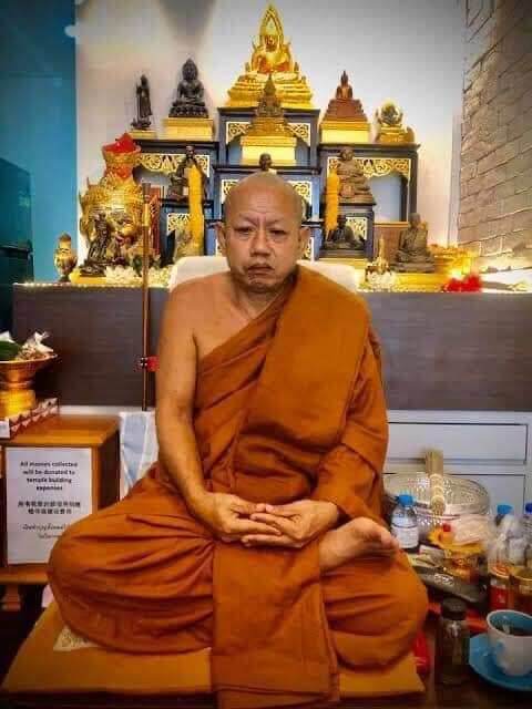 Monk seated before shrine with amulet bracelet Phaya Tao Ruen Amulet Blessed by Phra Ajarn Uthai