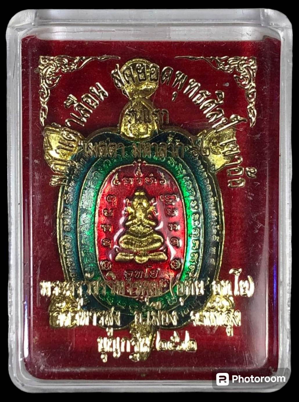 Gold and enamel turtle amulet in display case on red velvet background Phaya Tao Ruen Amulet Blessed by Phra Ajarn Uthai.