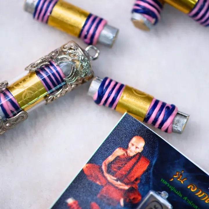 akrut Maha Prap – Protective Amulet tubular takrut amulets wrapped in pink and blue thread with silver case and monk photo card