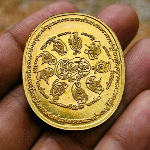 28 Buddhas amulet for protection gold charm with intricate Thai inscriptions held in hand