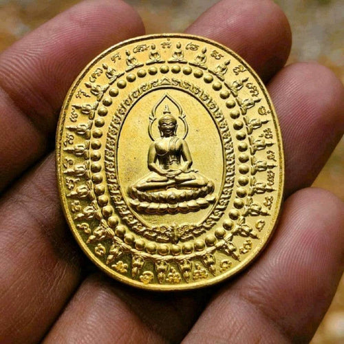 28 Buddhas amulet for protection gold-colored oval charm with engraved Buddha figure held in hand