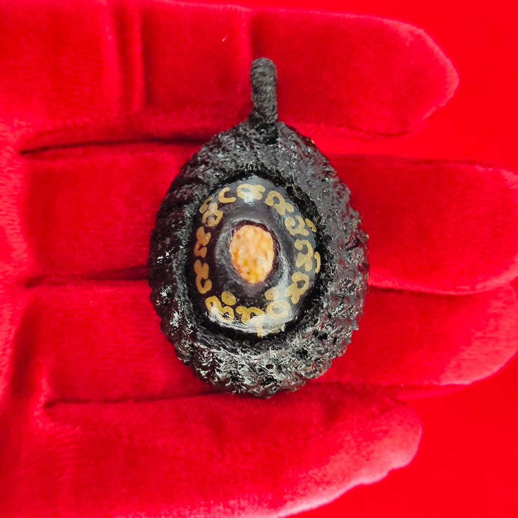 Bia Gae amulet for protection shown in hand, featuring intricate designs and detailed craftsmanship