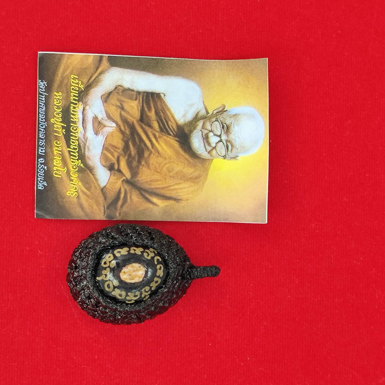 Bia Gae amulet for protection with accompanying card featuring a monk's image for spiritual well-being