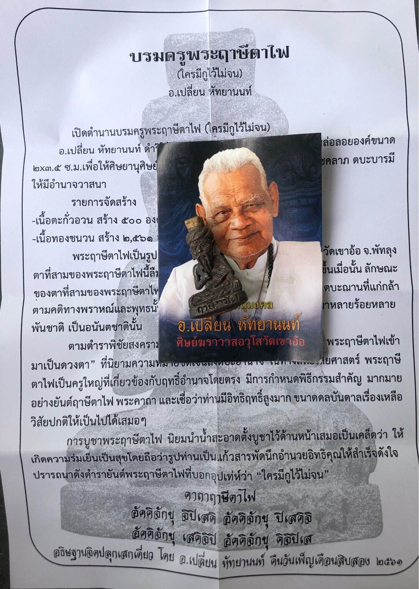 Borom Kru Phra Ruesi Ta Fai Amulet card with elderly monk portrait and small amulet on Thai text background