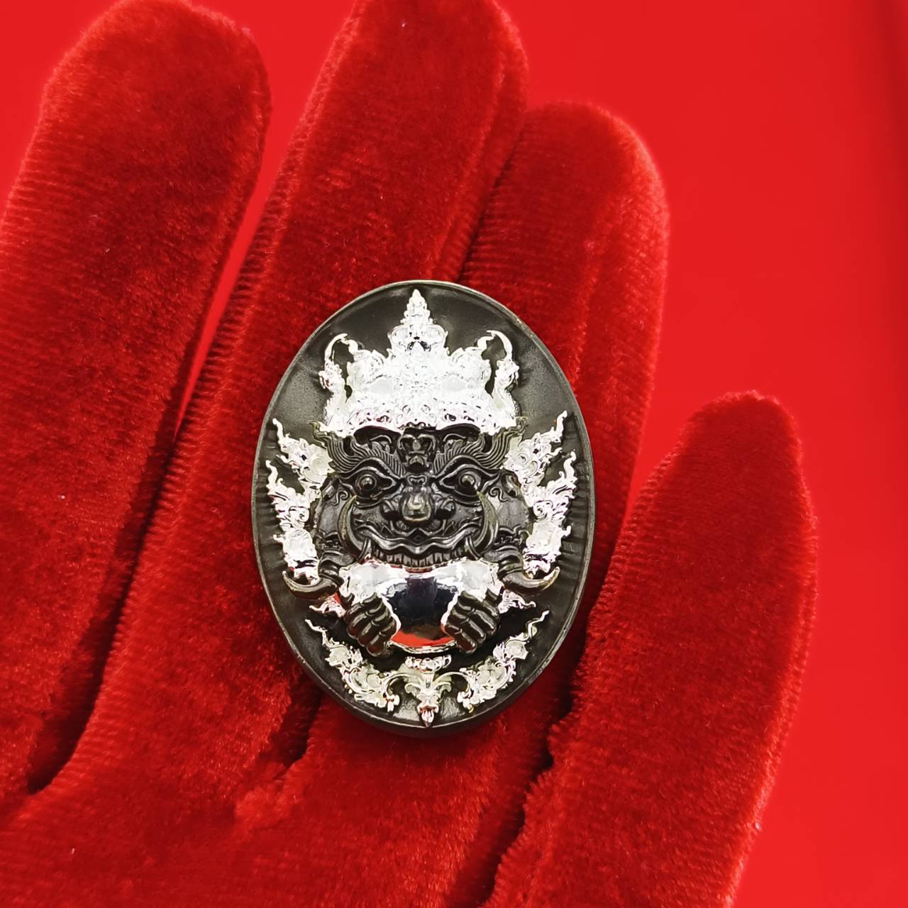 Rahu amulet coin for prosperity featuring intricate design on a velvet background