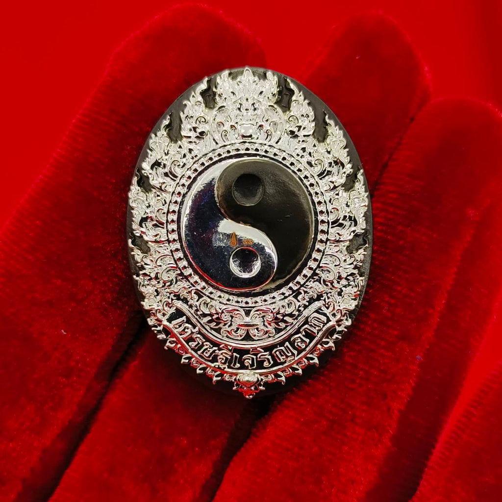 Rahu amulet coin for prosperity with intricate silver detailing and a yin-yang symbol