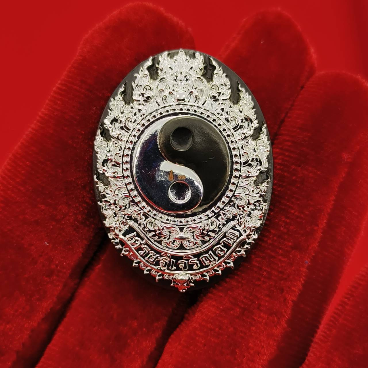 Rahu amulet coin for prosperity with intricate silver detailing and a yin-yang symbol