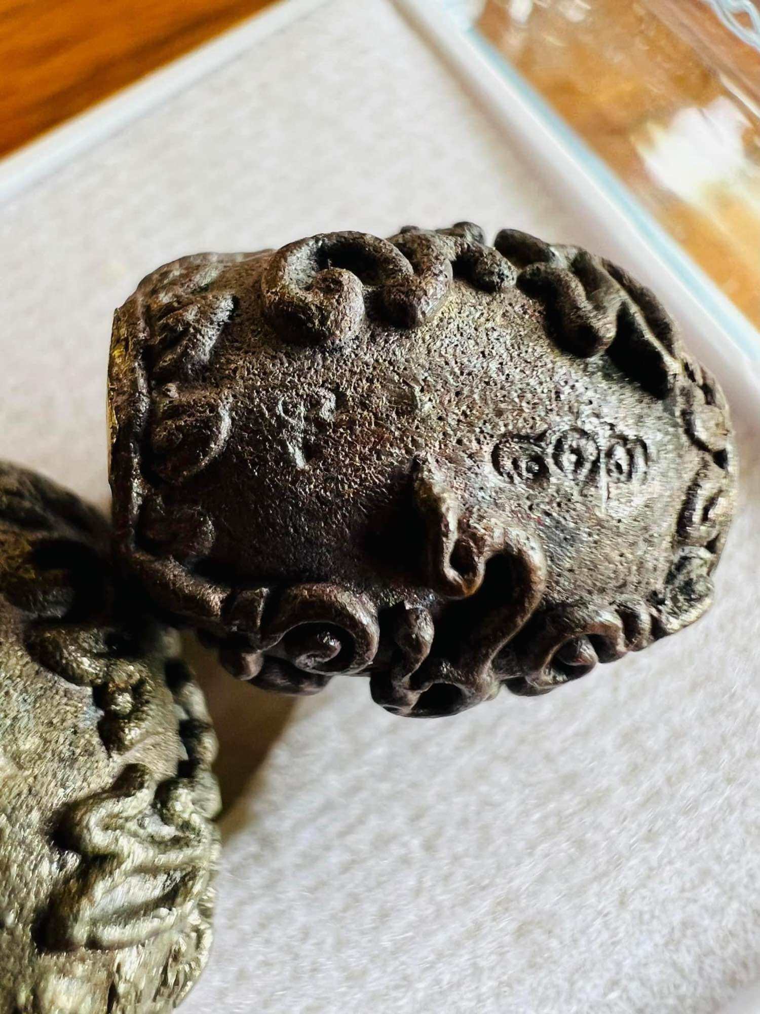 Thai Blessing Co carved metal talisman with ornate script and swirls for negative energy protection charm