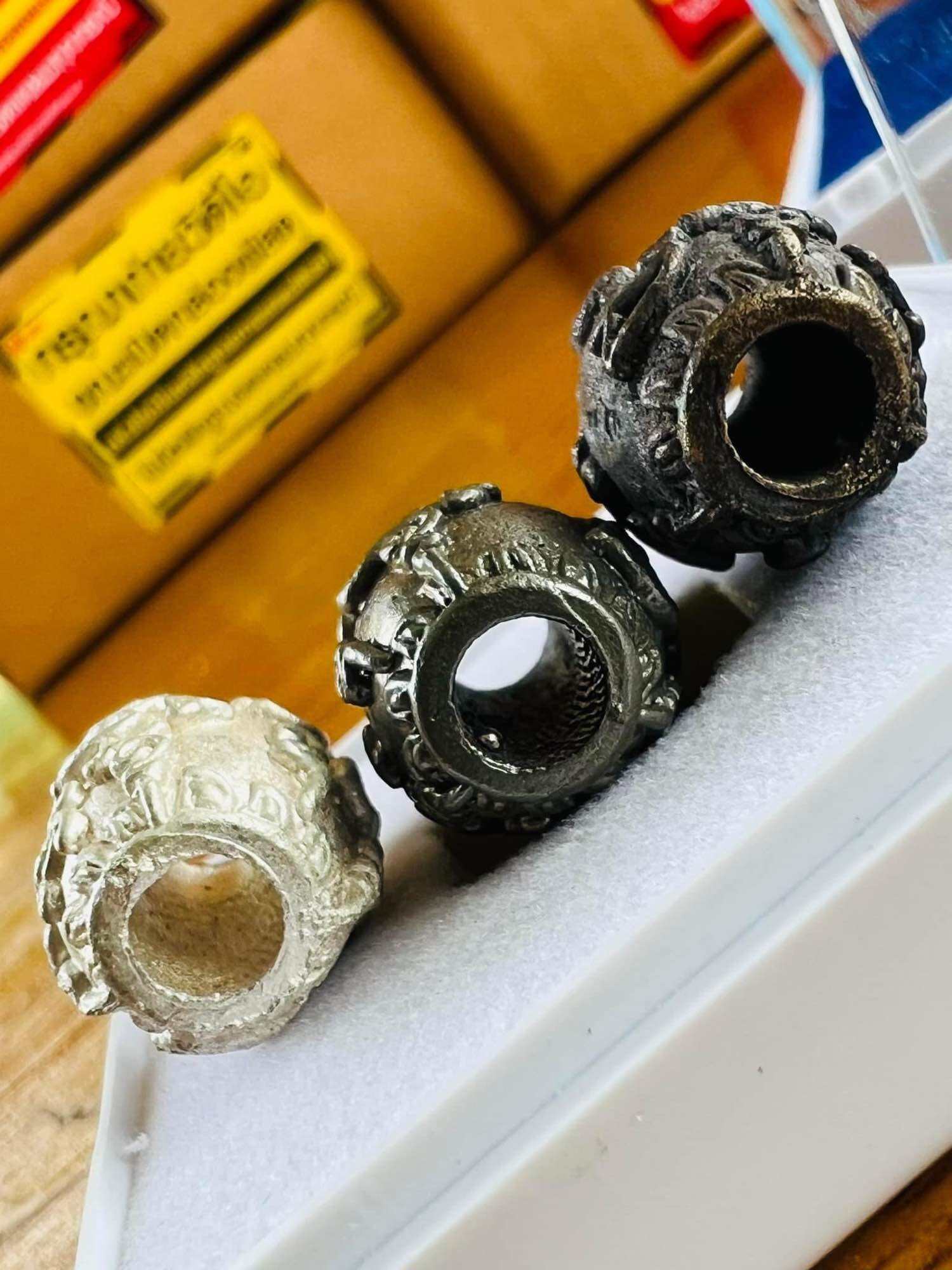 Thai Blessing Co carved tubular amulet beads in ivory pewter and dark bronze on foam display negative energy protection charm