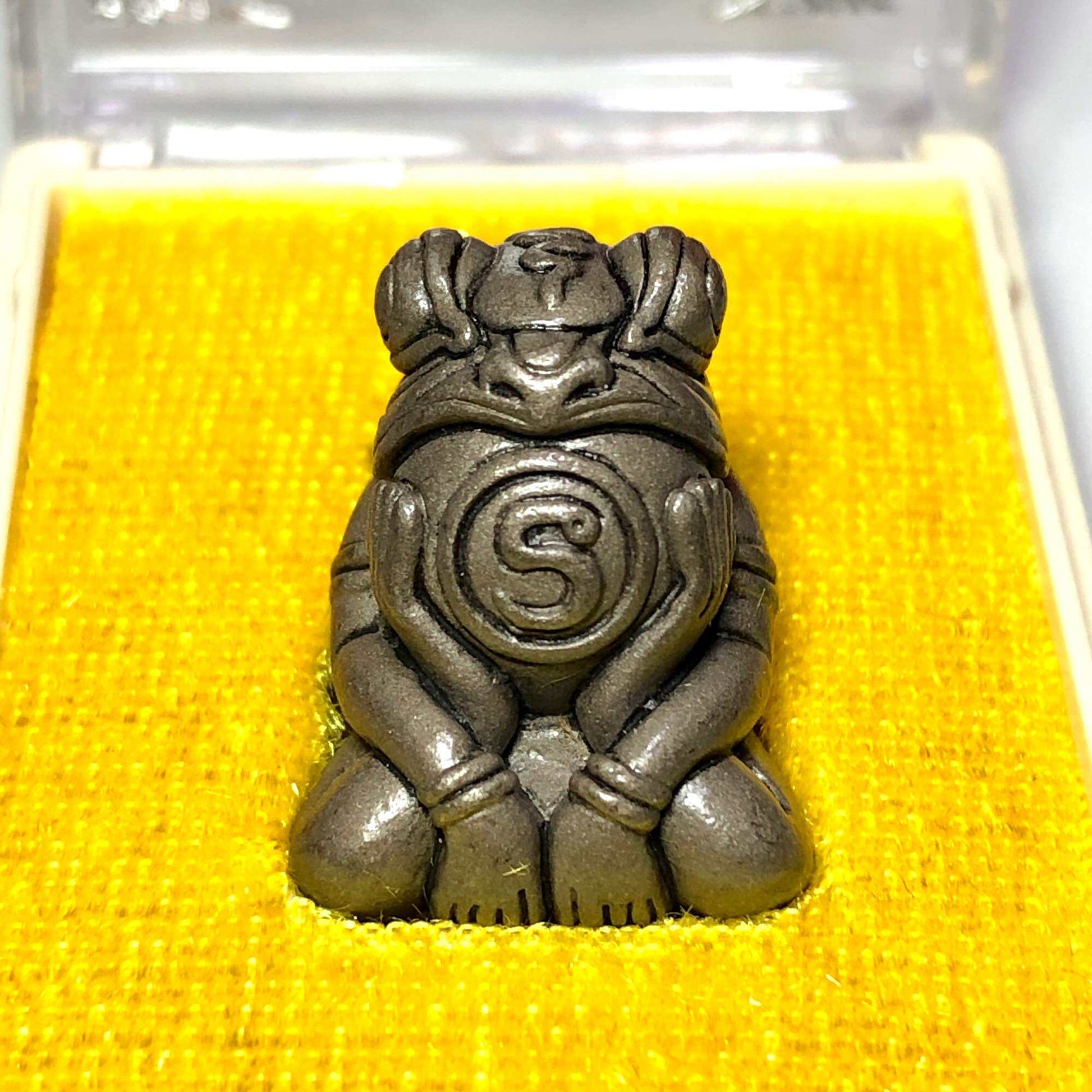 Phaya Kob Kin Duean metal frog amulet pendant on yellow velvet display case by Thai Blessing Co