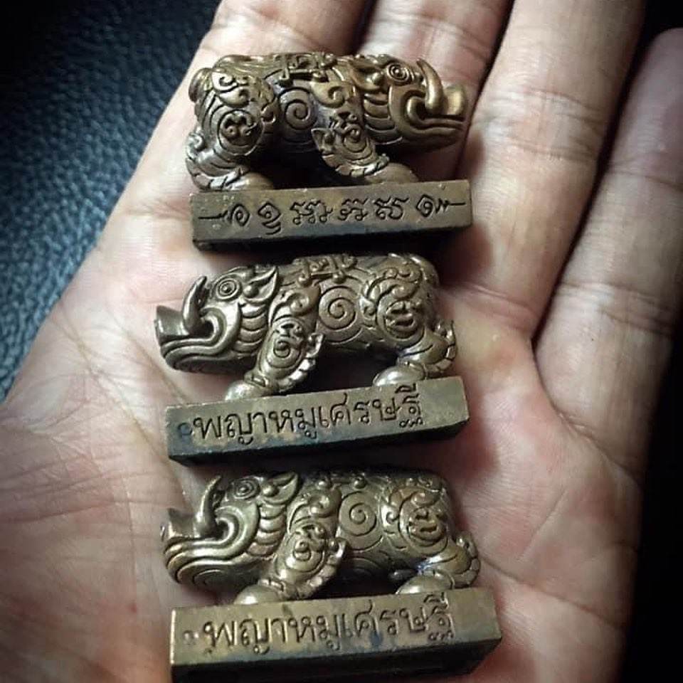Phaya Moo Setthi brass auspicious boar amulets on palm with engraved Thai base for feng shui