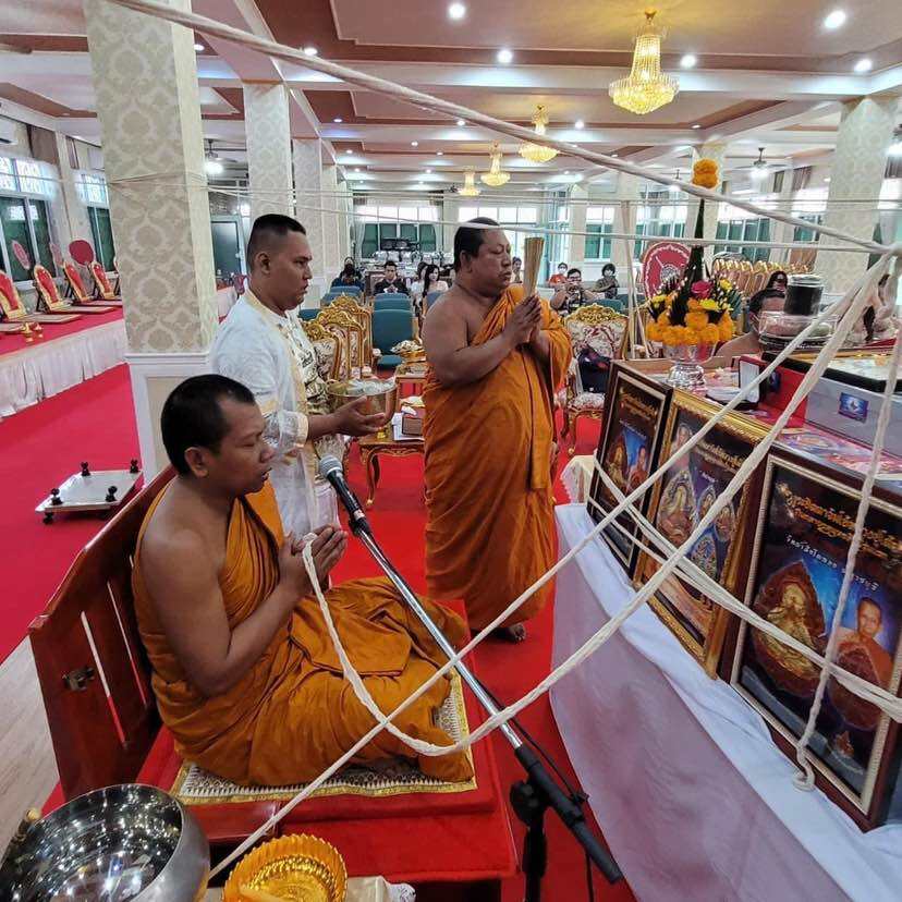 Buddhist monks performing a blessing ceremony for Phra Pidta amulet for prosperity in a temple setting