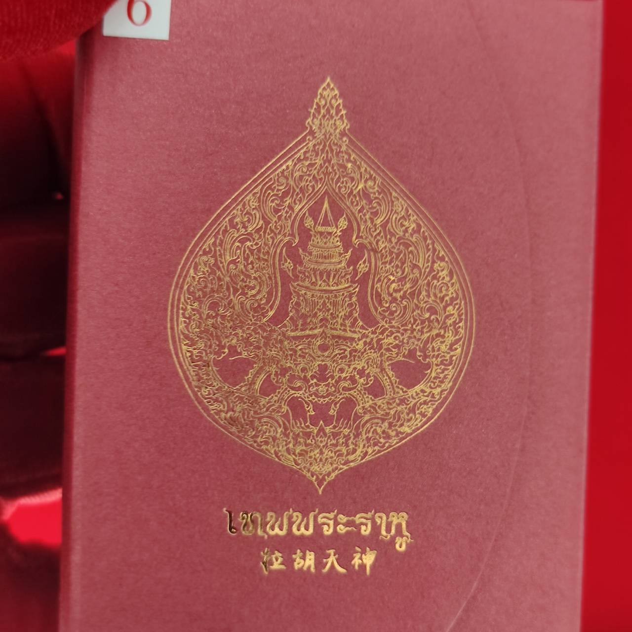 Rahu amulet for fortune packaged in a decorative pink box featuring intricate gold designs