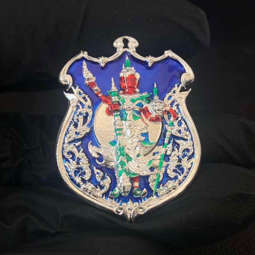Shield shaped silver amulet with blue enamel and red green guardian deity holding weapons Thao Wessuwanno Sodaprom .