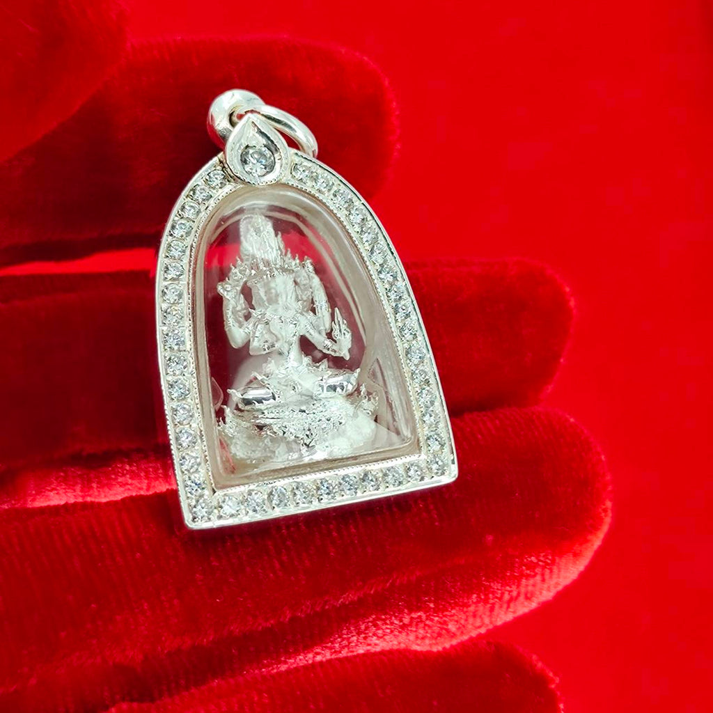 Brahma Naga amulet with silver frame. Detailed silver pendant with jeweled border in clear case on red velvet glove