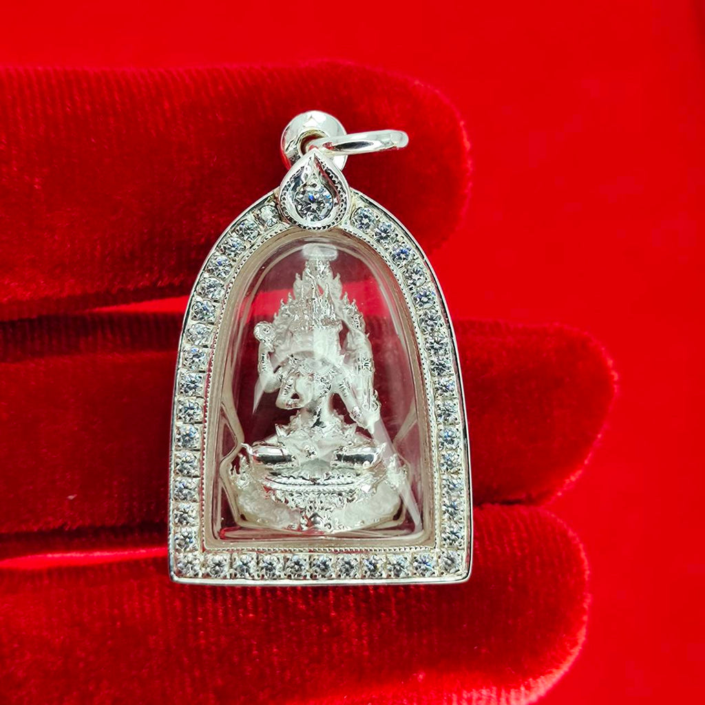 Brahma Naga amulet with silver frame. Pendant in clear case with rhinestones on red velvet background