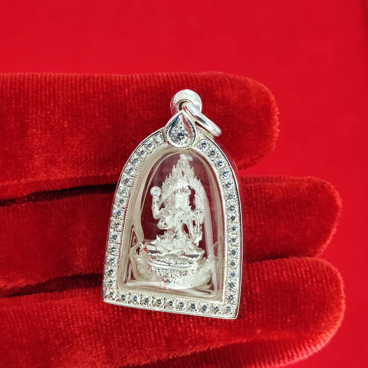 Brahma Naga amulet with silver frame displayed in crystal studded silver case on red velvet glove