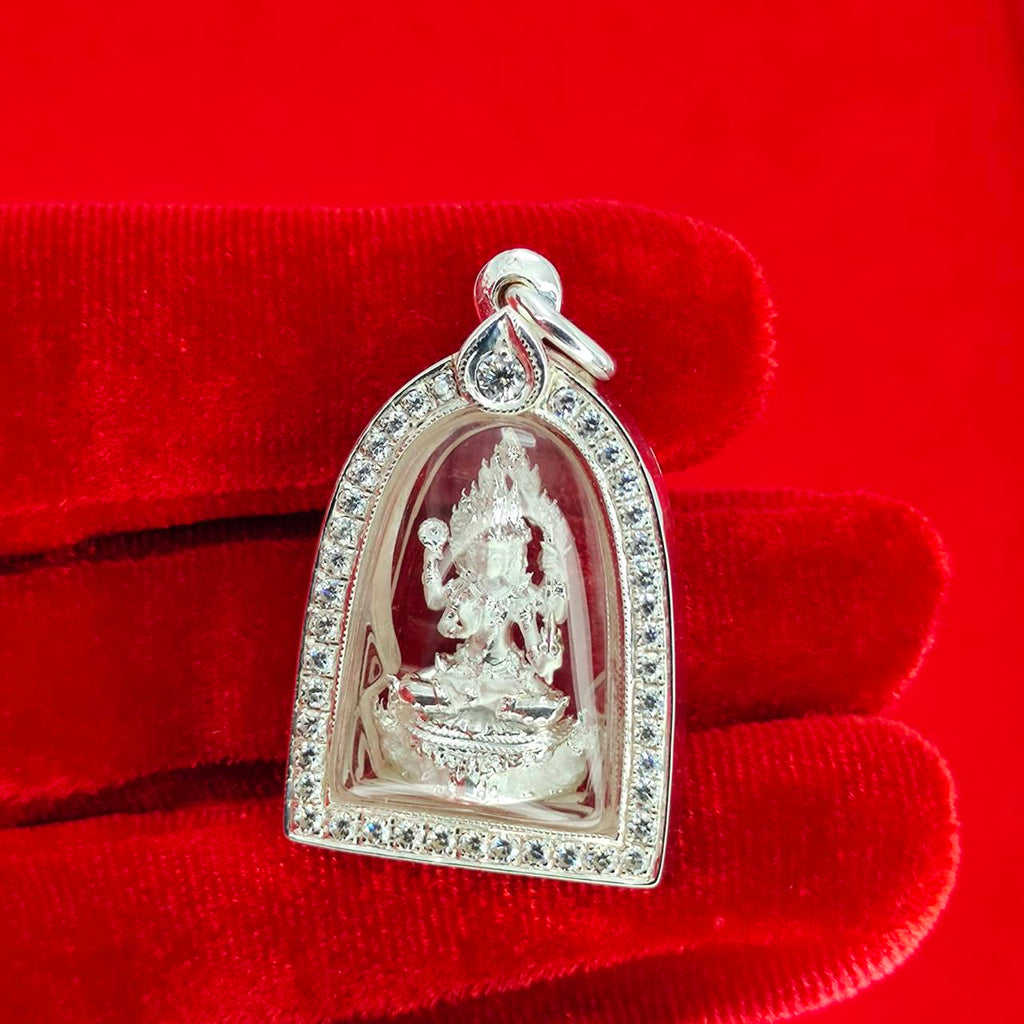 Brahma Naga amulet with silver frame. Detailed silver deity pendant with rhinestone border on red velvet glove