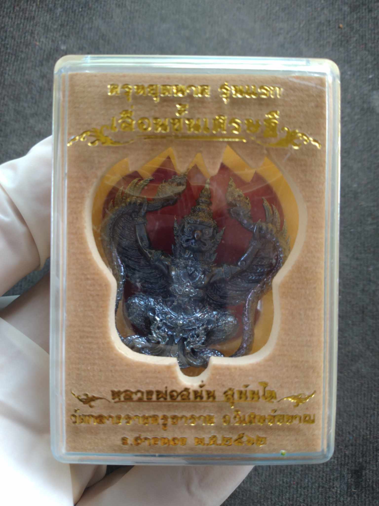 Garuda amulet blessed by Luang Pho Sanan in plastic display case with gold Thai script by Thai Blessing Co