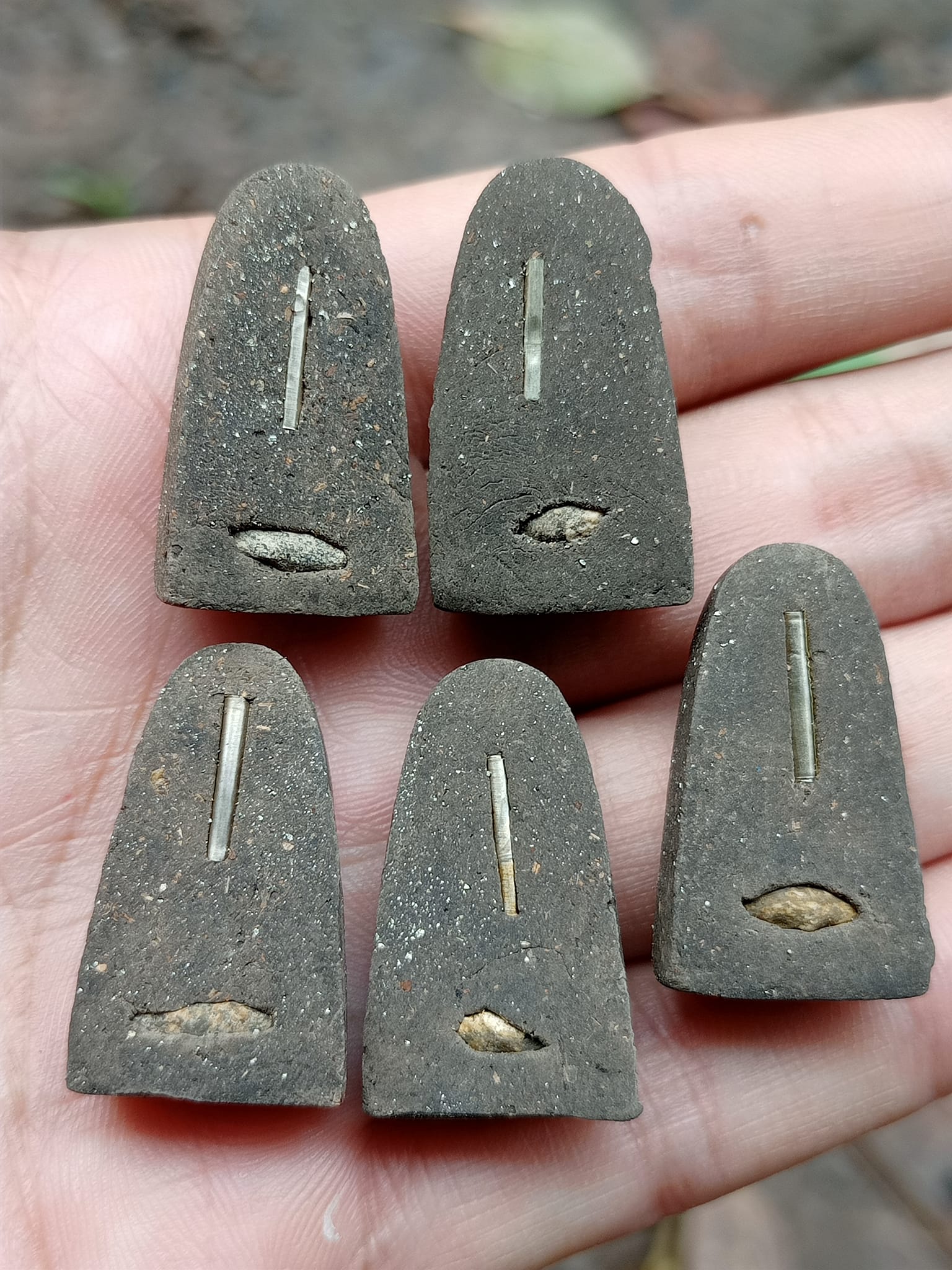 Five Luang Pu Thuad commemorative amulet 2023 clay amulets with metal inlay held in hand