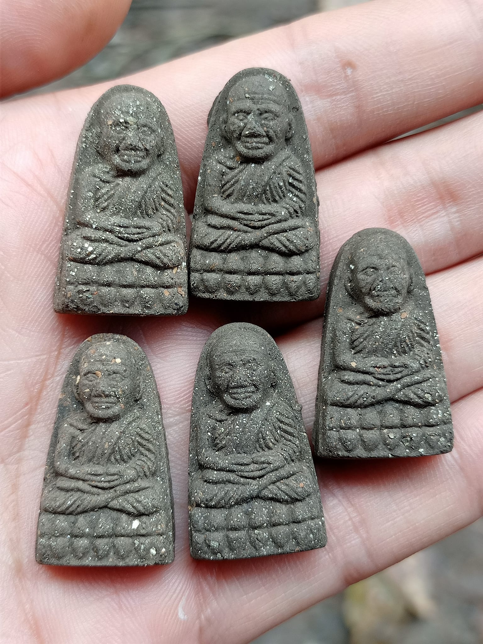 Set of five small dark Luang Pu Thuad commemorative amulet 2023 on a palm by Thai Blessing Co