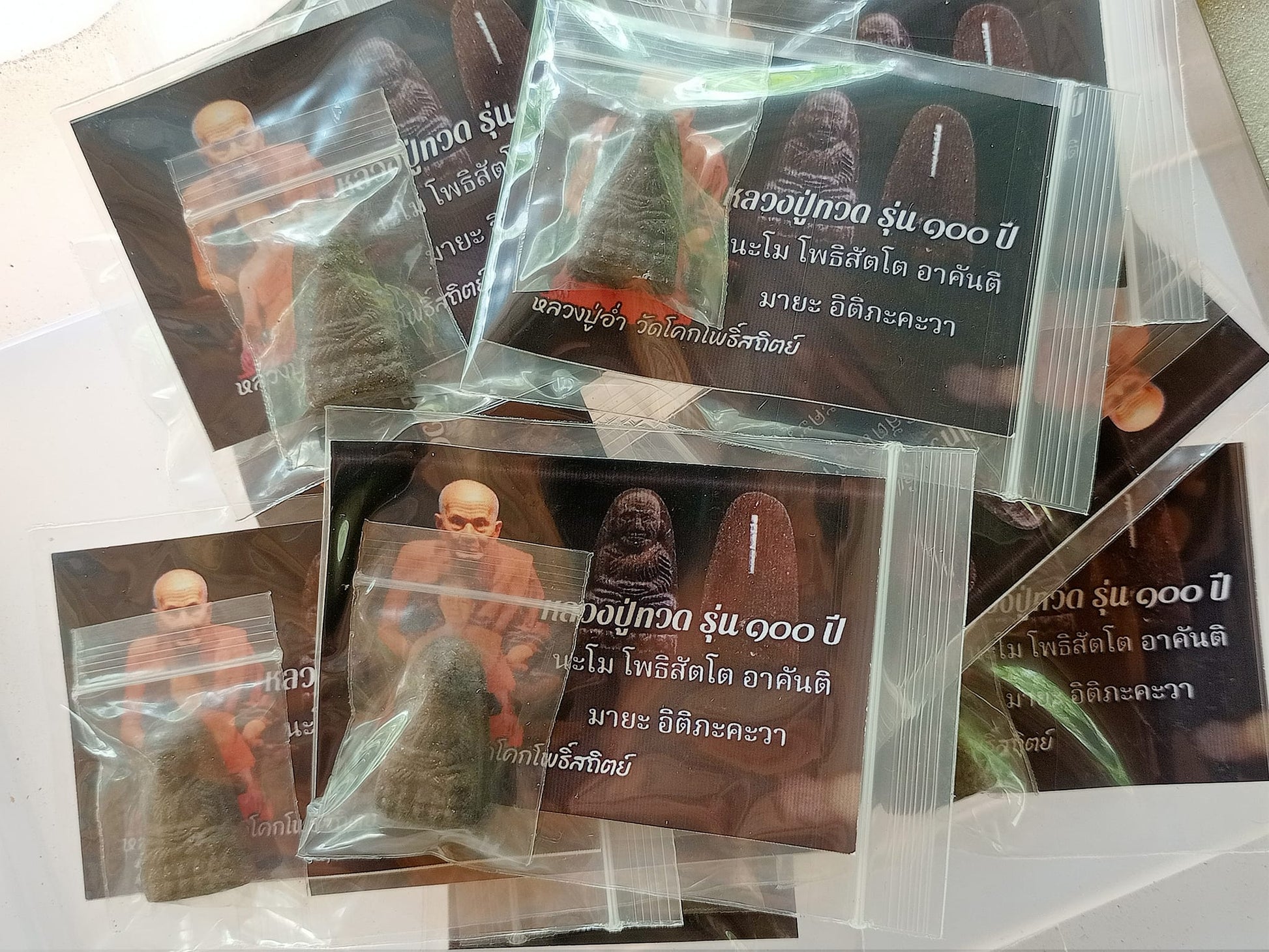 Thai Blessing Co multiple packaged small amulets and cards featuring monk image Luang Pu Thuad commemorative amulet 2023