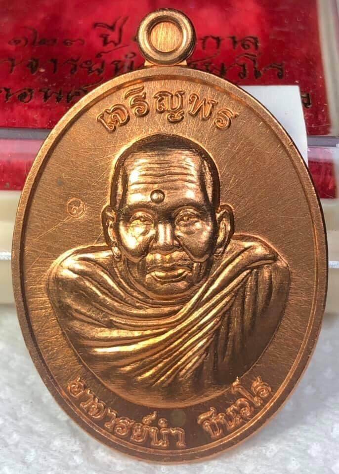 Phra Charoen Phon Hoom Kloom amulet copper oval medallion featuring a detailed monk bust with Thai script and hanging loop