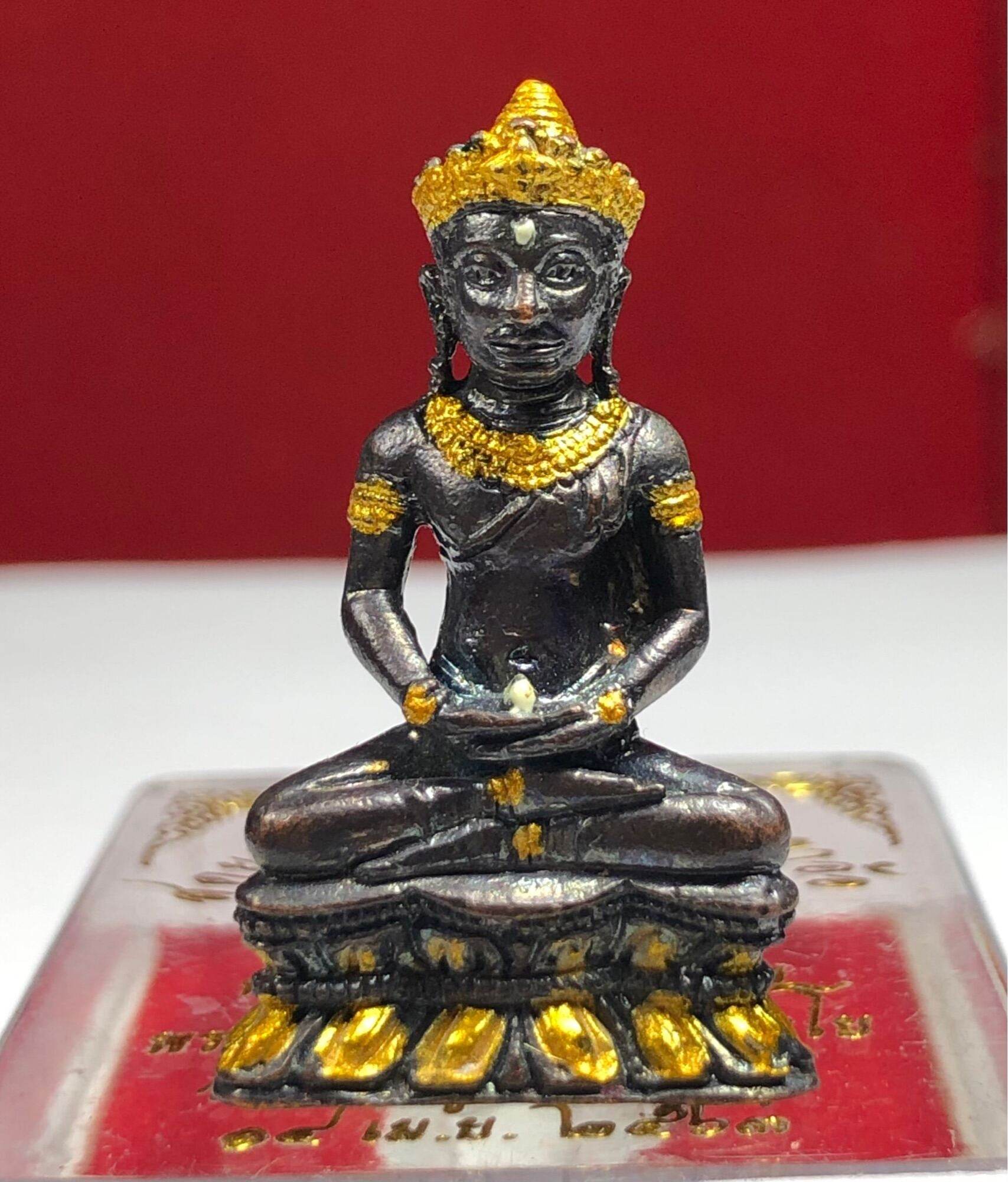 Phra Kring Arkom Amulet small seated black metal statue with gold accents on red display base and intricate detailing