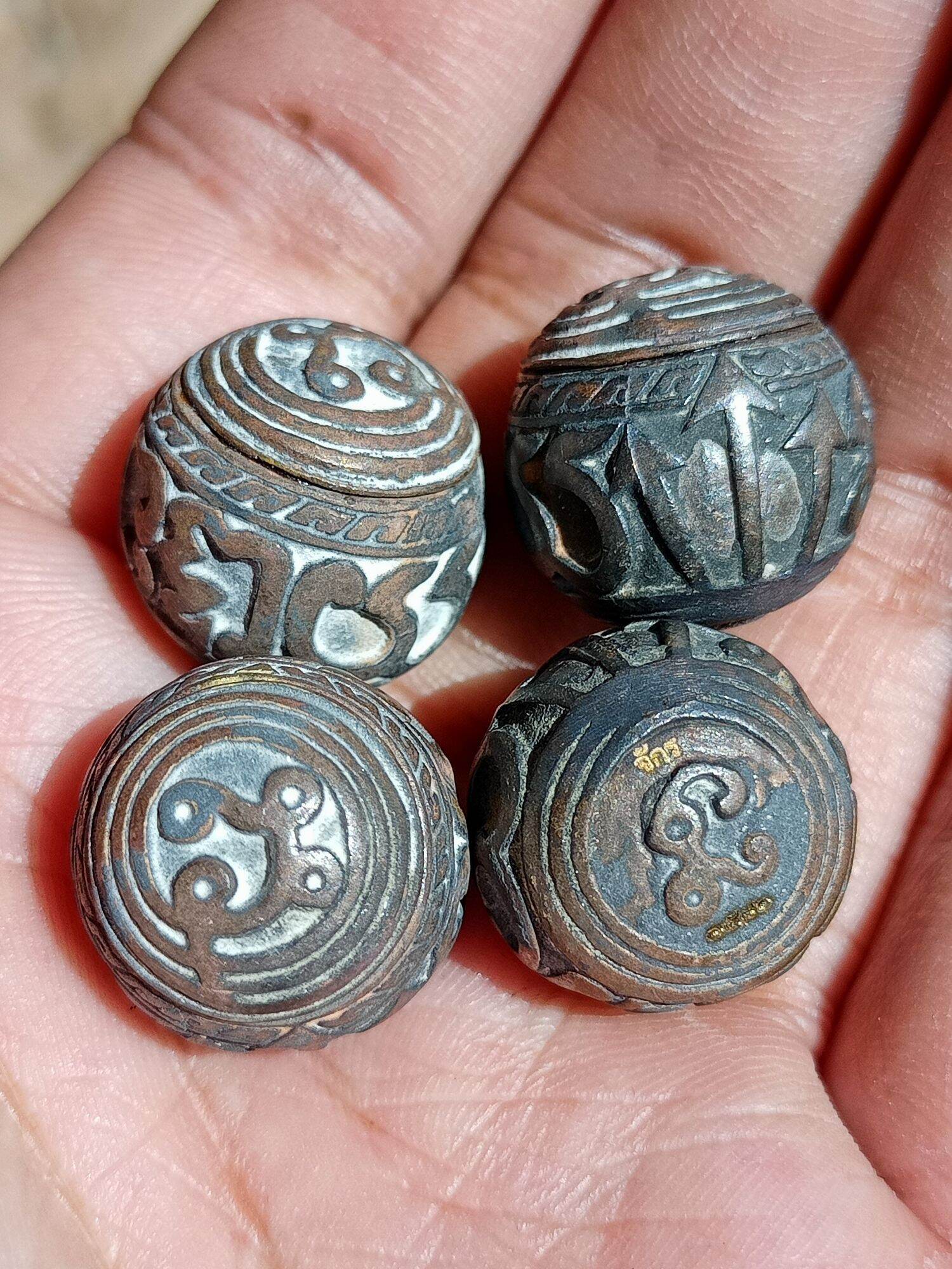 Thai Blessing Co sacred bullet amulet Thailand set of four engraved metal talismans in palm