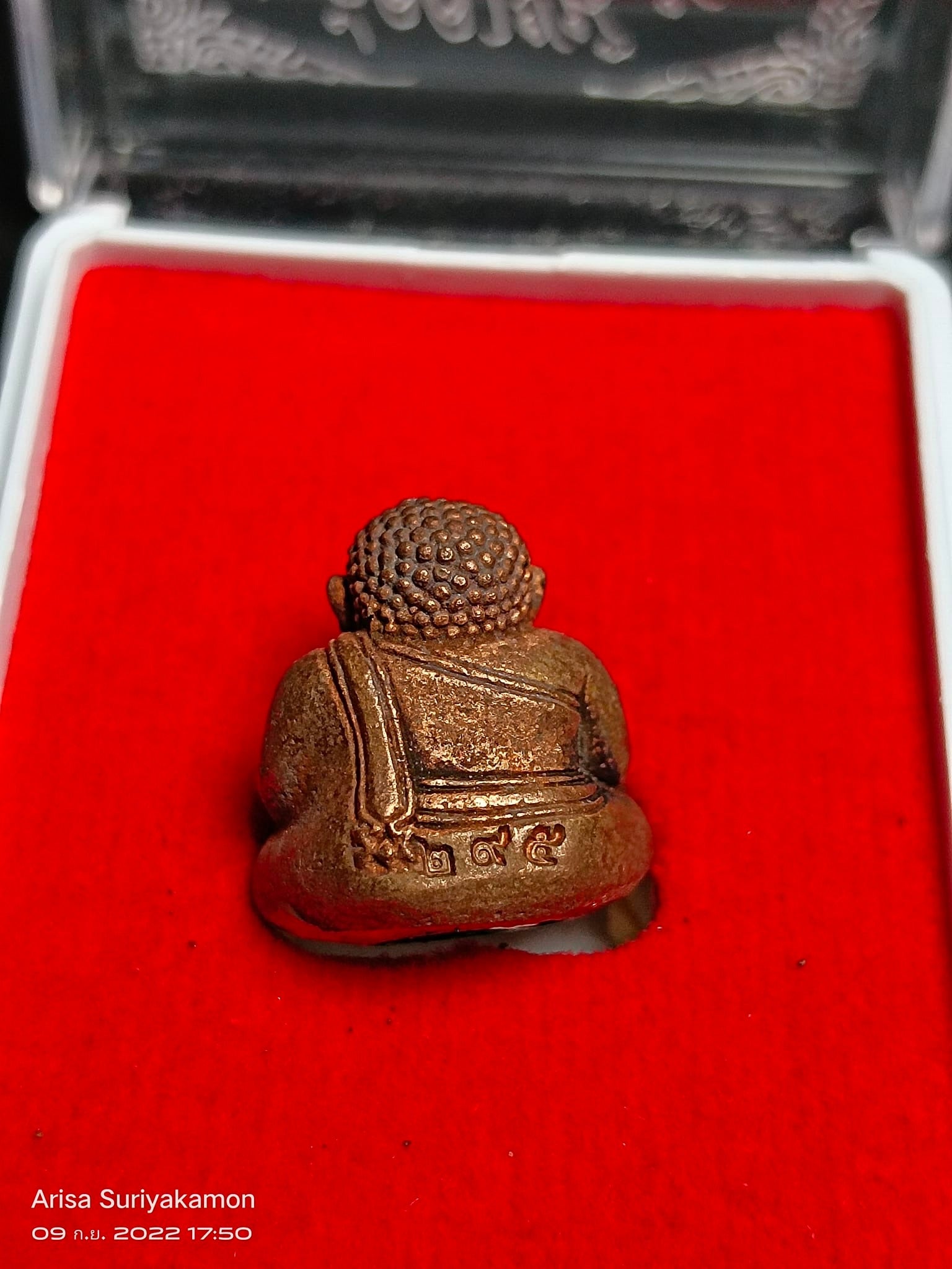 Sangkajai Buddha amulet for wealth bronze seated back view on red velvet display box from Thai Blessing Co
