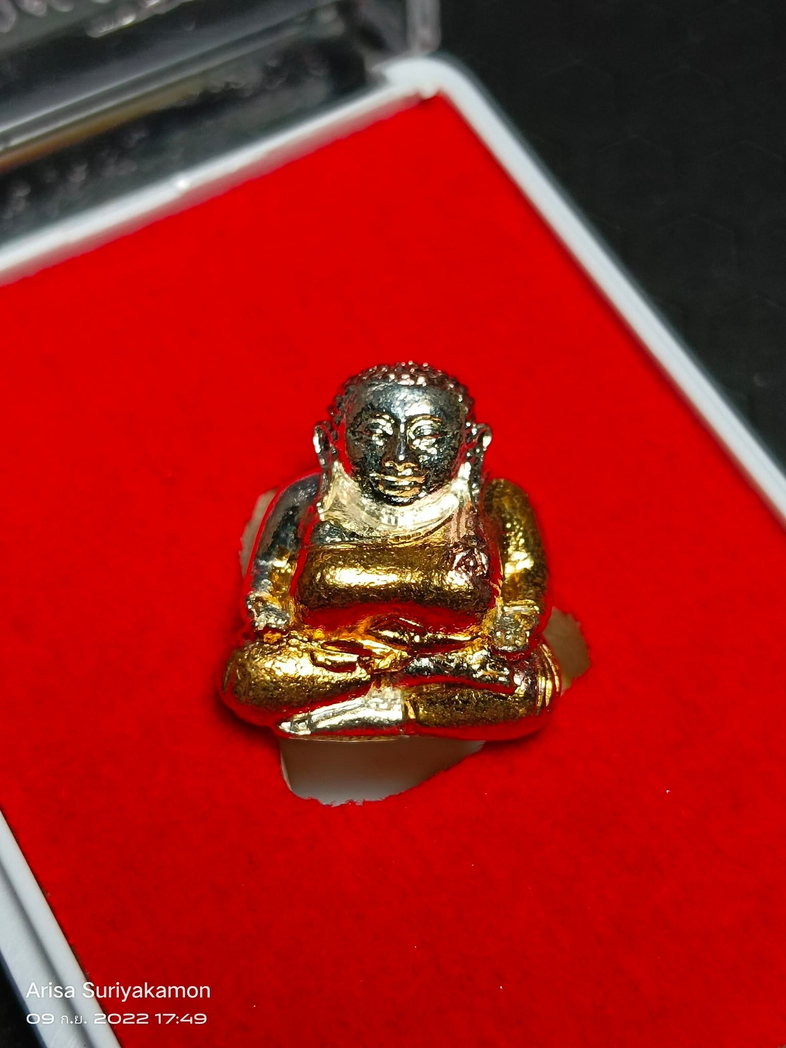 Gold Sangkajai Buddha amulet for wealth seated statue on red velvet display by Thai Blessing Co