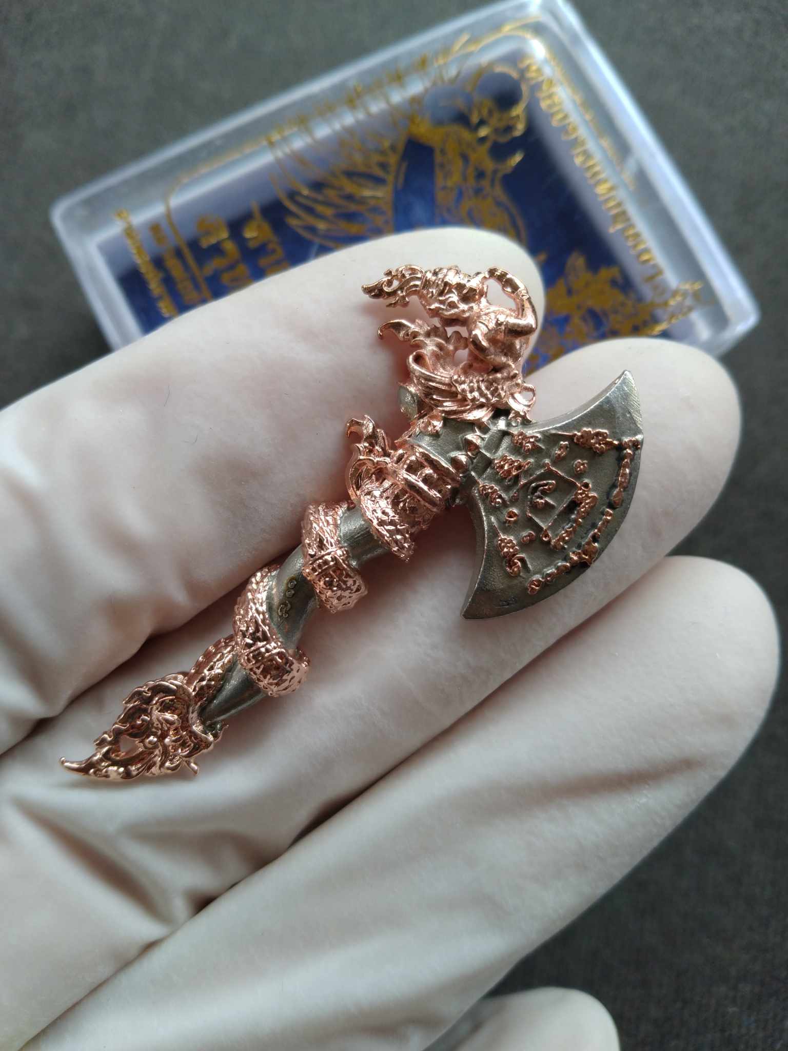 Sky Axe Krut Thawet amulet copper and silver axe pendant with detailed Garuda and naga wrap held in gloved hand