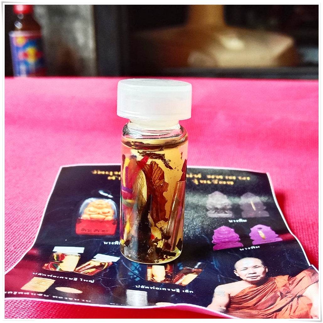 Thai love and fortune talisman small glass vial of blessed oil with herbs on Thai Blessing Co brochure