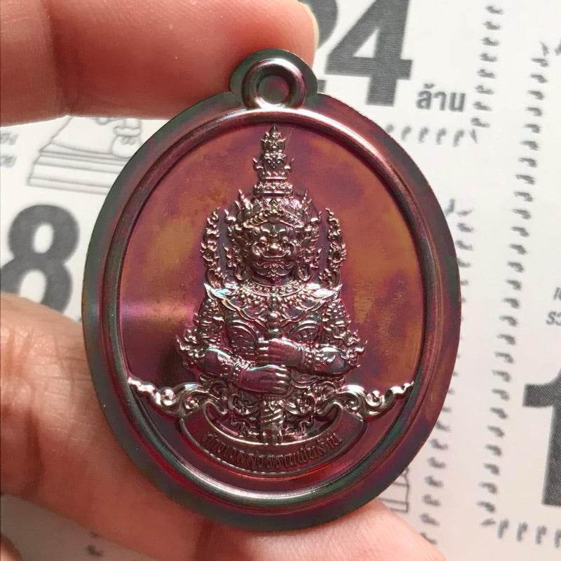 Thai Blessing Co Thao Wessuwan amulet for wealth oval iridescent metal pendant held in hand