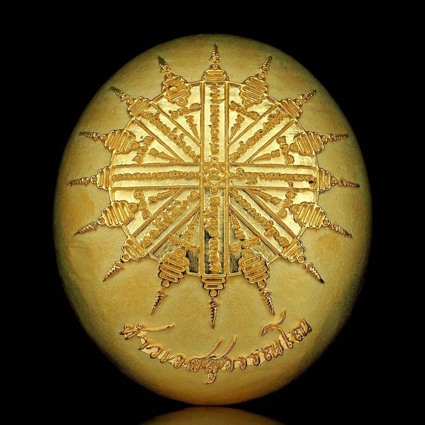 Gold oval amulet with intricate yantra star design and Thai script Thao Wessuwanno Bandarn Patthanapon