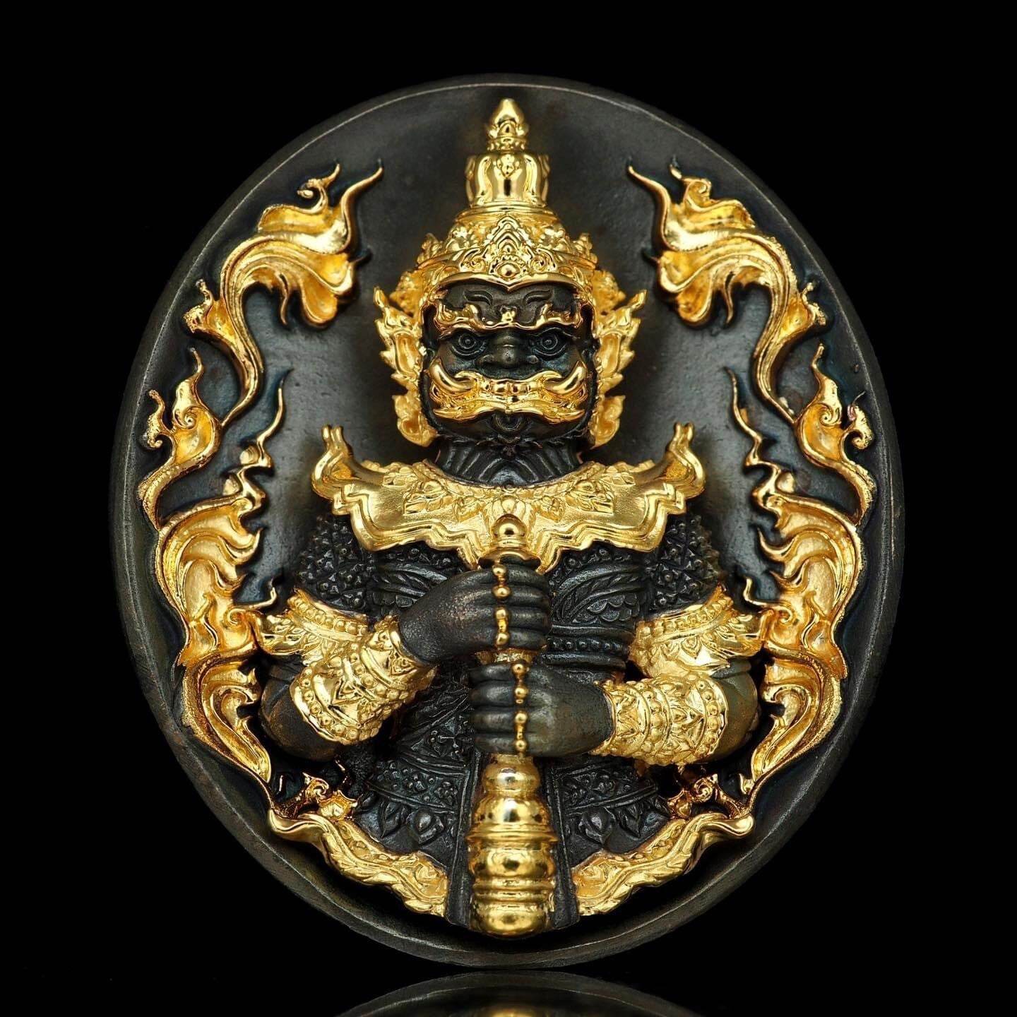 Black and gold oval protective amulet medallion featuring guardian figure holding club Thao Wessuwanno Bandarn Patthanapon