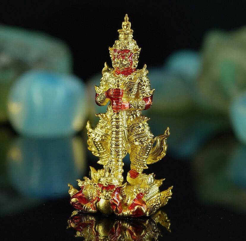 Gold and red Thai guardian amulet figurine standing on lotus base Thao Wessuwanno . decorative talisman