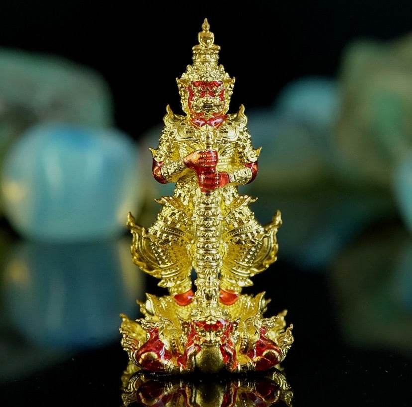 Gold Thai guardian figurine amulet detailed red accents on pedestal representing Thao Wessuwanno .