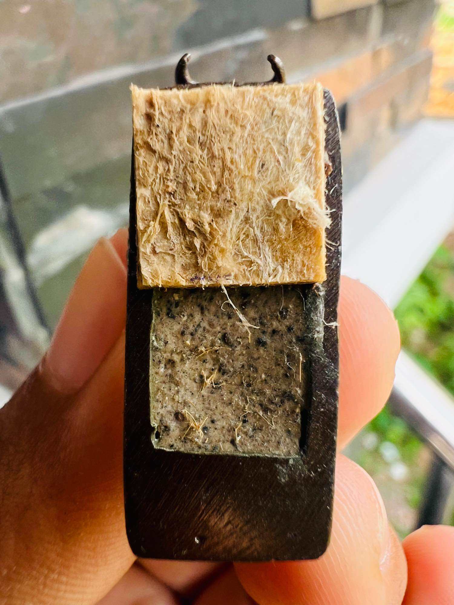 Wua Thanu Thai protection amulet dark wooden frame with two sacred fiber panels and metal loop held in hand